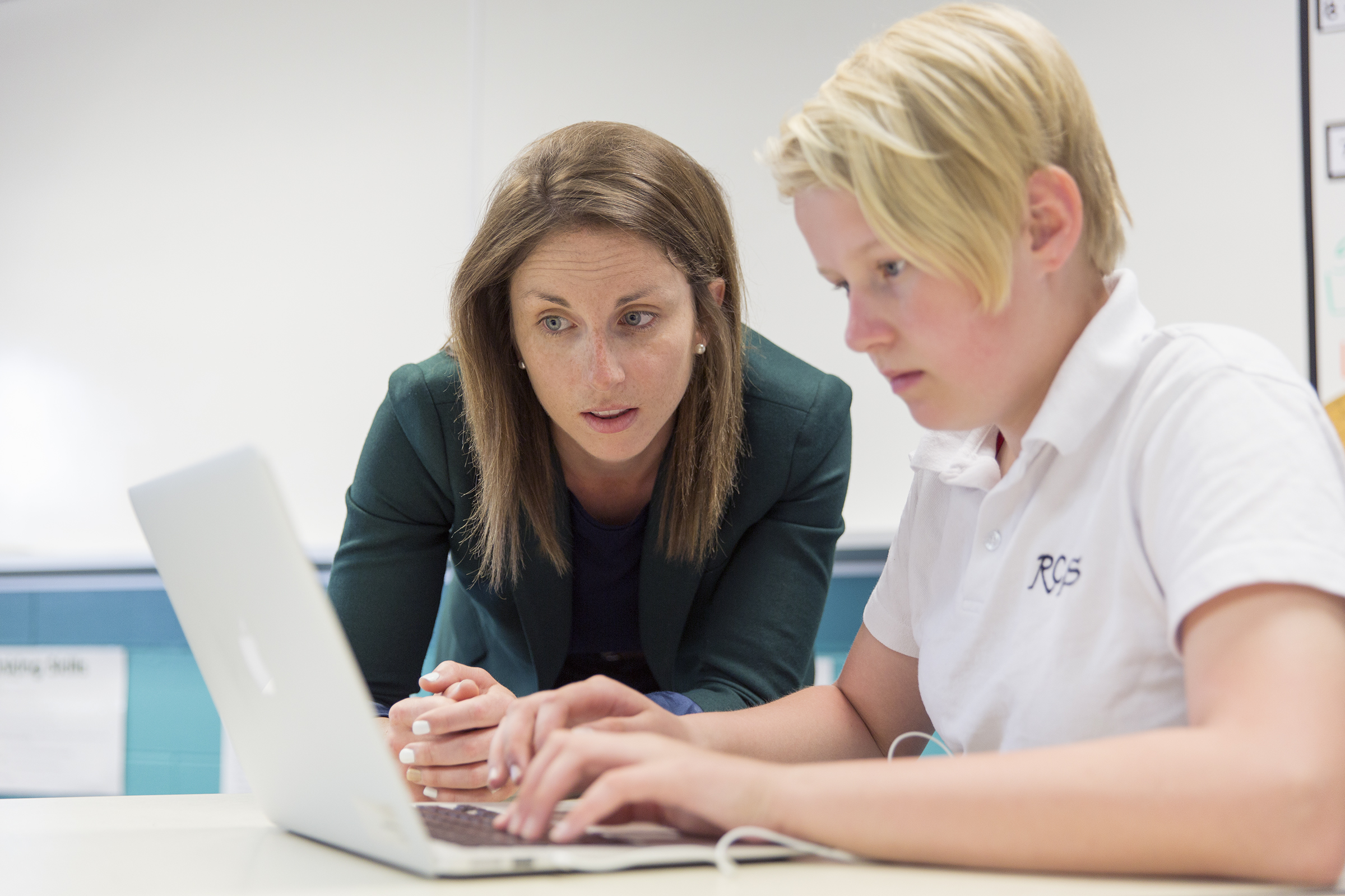 photo of teacher supporting a student  on class